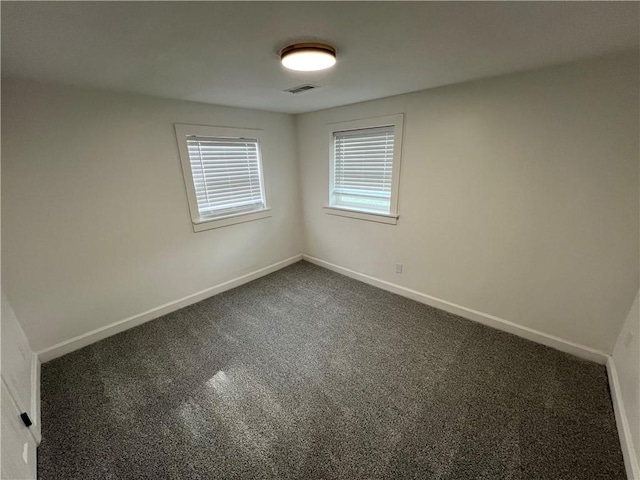 7104 N Cherry St, Gladstone, MO 64118 - empty room featuring dark colored carpet and baseboards