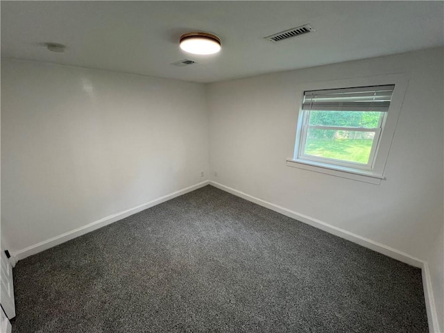 7104 N Cherry St, Gladstone, MO 64118 - empty room featuring dark colored carpet and a smoke detector
