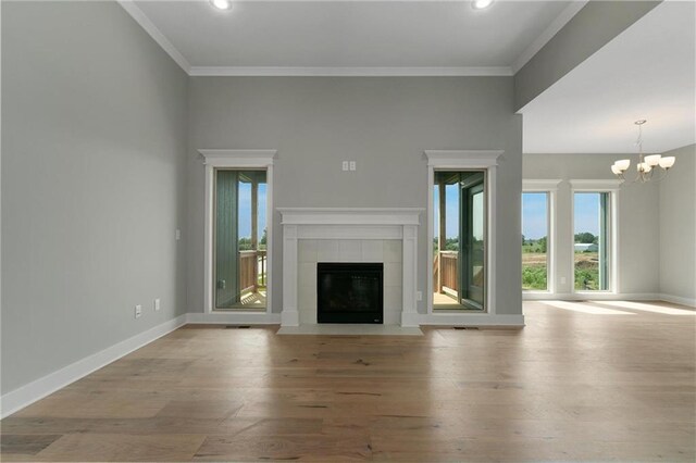 3707 NE 90th St, Kansas City, MO 64156 - unfurnished living room with a chandelier, wood finished floors, a tile fireplace, recessed lighting, and ornamental molding