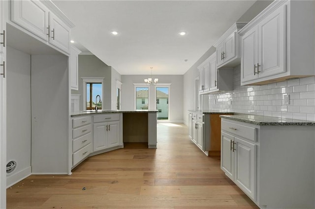 3707 NE 90th St, Kansas City, MO 64156 - kitchen featuring a chandelier, light wood-type flooring, white cabinets, a peninsula, and recessed lighting
