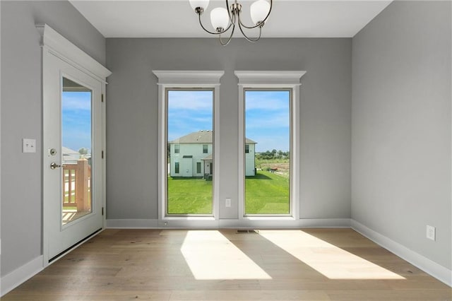3707 NE 90th St, Kansas City, MO 64156 - unfurnished room featuring a chandelier, plenty of natural light, and wood finished floors