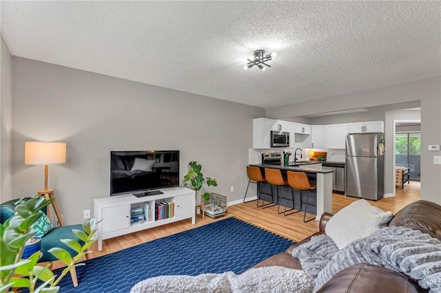 1509 W 25th Ct Unit A2, Lawrence, KS 66046 - living area with light wood-type flooring and a textured ceiling