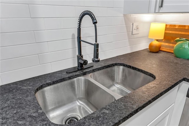 1509 W 25th Ct Unit A2, Lawrence, KS 66046 - kitchen view of backsplash, white cabinets, and dark stone countertops