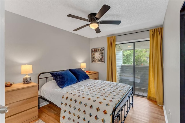 1509 W 25th Ct Unit A2, Lawrence, KS 66046 - bedroom with access to exterior, light wood-style floors, a textured ceiling, and ceiling fan
