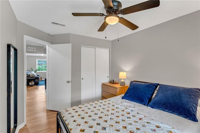 1509 W 25th Ct Unit A2, Lawrence, KS 66046 - bedroom featuring light wood-style floors, a closet, ceiling fan, and a textured ceiling