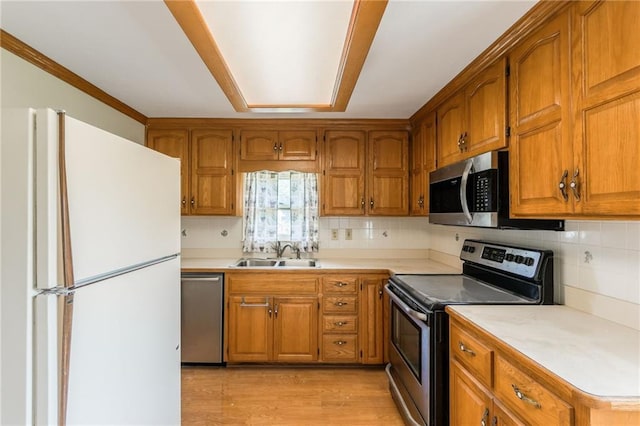 7306 N Holmes Ave, Gladstone, MO 64118 - kitchen featuring appliances with stainless steel finishes, brown cabinetry, and light countertops