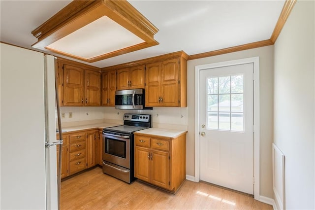 7306 N Holmes Ave, Gladstone, MO 64118 - kitchen featuring stainless steel appliances, light countertops, light wood-style flooring, brown cabinetry, and crown molding