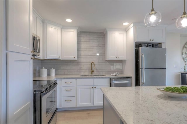 4545 Wornall Rd Unit 1009, Kansas City, MO 64111 - kitchen featuring appliances with stainless steel finishes, white cabinets, tasteful backsplash, light stone countertops, and recessed lighting