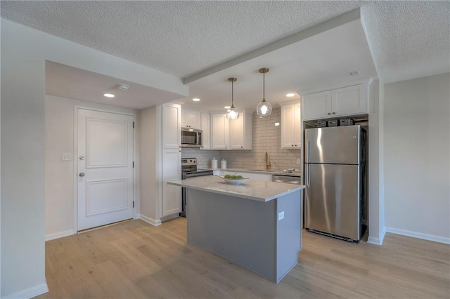 4545 Wornall Rd Unit 1009, Kansas City, MO 64111 - kitchen with stainless steel appliances, light wood-style floors, a textured ceiling, backsplash, and white cabinetry