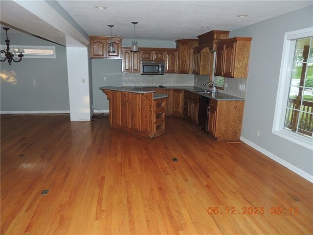 326 Virginia Rd, Excelsior Springs, MO 64024 - kitchen with stainless steel microwave, dishwashing machine, a kitchen island, and backsplash