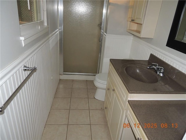 326 Virginia Rd, Excelsior Springs, MO 64024 - bathroom with a stall shower, vanity, a decorative wall, tile patterned flooring, and wainscoting