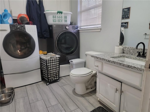 19400 E 13th St N, Independence, MO 64056 - bathroom with washing machine and dryer, vanity, wood finish floors, and a shower