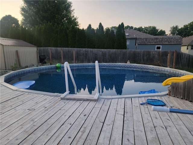 19400 E 13th St N, Independence, MO 64056 - pool at dusk featuring a wooden deck and a fenced backyard