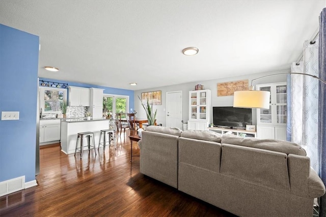 13500 Spring St, Grandview, MO 64030 - living room with dark wood-style flooring and baseboards