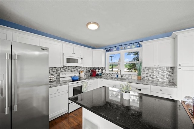 13500 Spring St, Grandview, MO 64030 - kitchen with white appliances, decorative backsplash, dark wood-style floors, and white cabinets