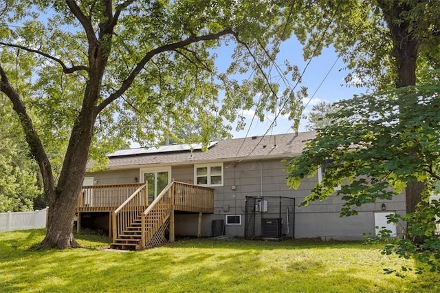 13500 Spring St, Grandview, MO 64030 - back of house with stairway, a wooden deck, and roof mounted solar panels