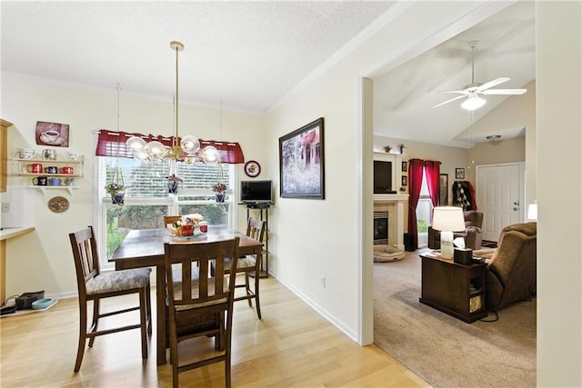 22802 W 72nd Ter, Shawnee, KS 66227 - dining area featuring ceiling fan, a glass covered fireplace, ornamental molding, light wood-style flooring, and a chandelier