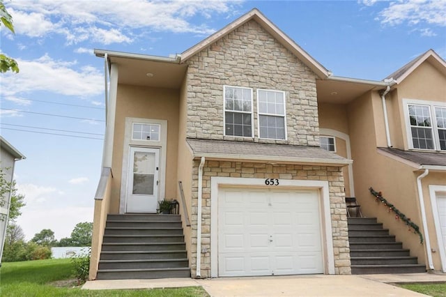 653 S Woodson Ln, Gardner, KS 66030 - multi unit property featuring stucco siding, stone siding, an attached garage, and driveway