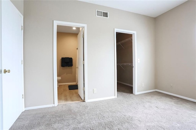 653 S Woodson Ln, Gardner, KS 66030 - unfurnished bedroom featuring carpet floors, a spacious closet, a closet, and ensuite bathroom