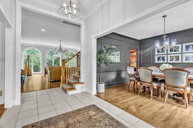 22810 SW Hampton Ct, Blue Springs, MO 64015 - dining space featuring a chandelier, crown molding, tile patterned floors, stairs, and a decorative wall