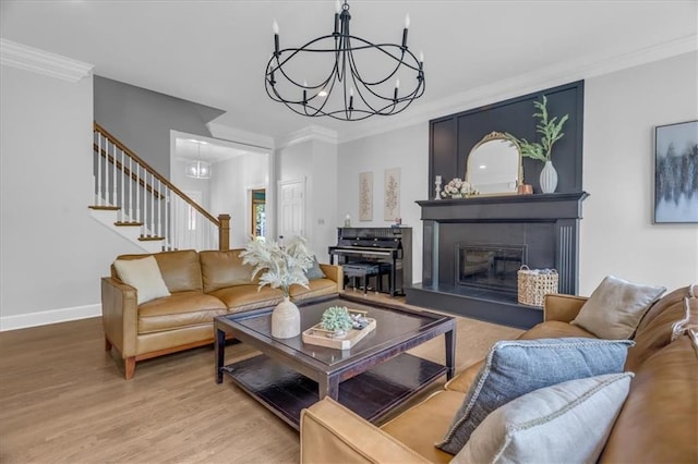 22810 SW Hampton Ct, Blue Springs, MO 64015 - living room with a chandelier, wood finished floors, stairway, ornamental molding, and a glass covered fireplace