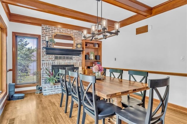 22810 SW Hampton Ct, Blue Springs, MO 64015 - dining space with beamed ceiling, healthy amount of natural light, light wood finished floors, a brick fireplace, and a chandelier