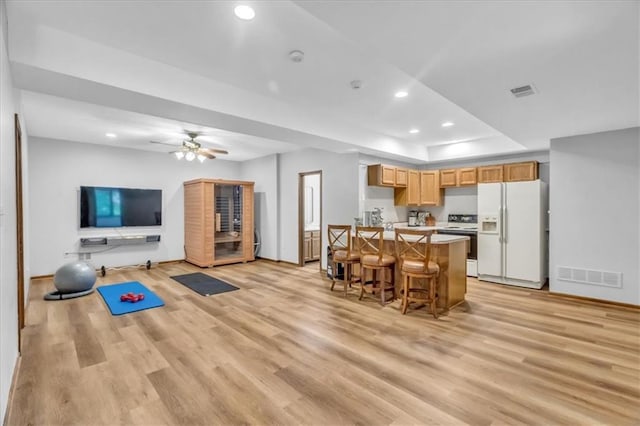 22810 SW Hampton Ct, Blue Springs, MO 64015 - kitchen featuring white appliances, light wood-type flooring, open floor plan, recessed lighting, and a breakfast bar area