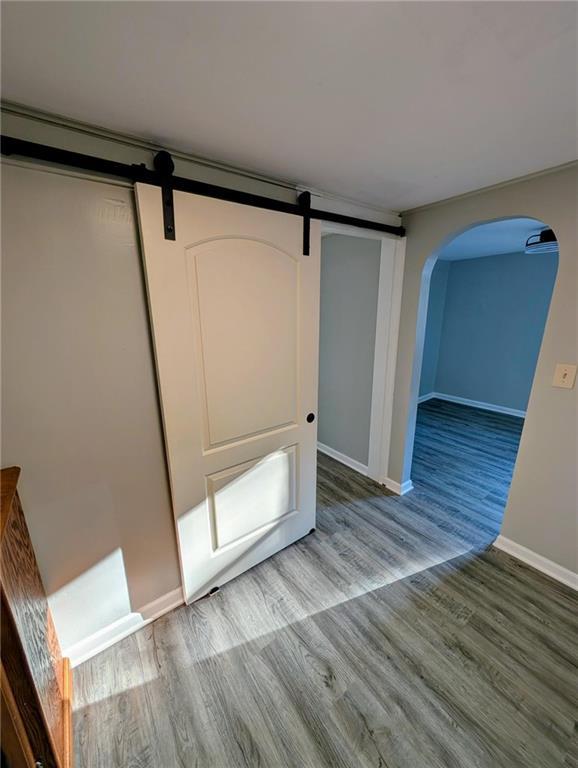 830 Locust St, Eudora, KS 66025 - interior space with wood finished floors, arched walkways, and a barn door