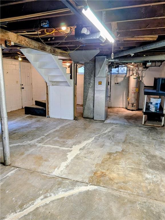 830 Locust St, Eudora, KS 66025 - below grade area with water heater, stairway, heating unit, and healthy amount of natural light
