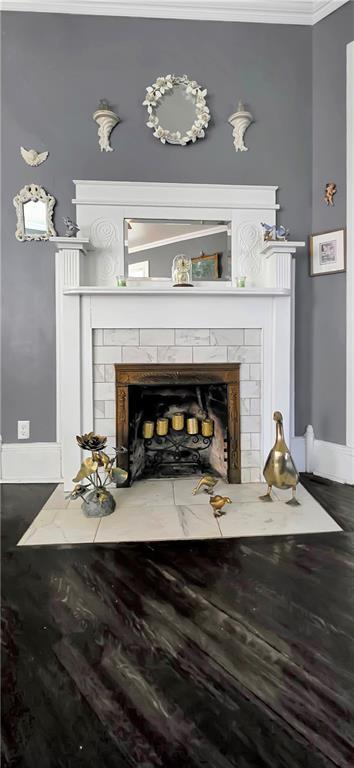 615 N Jefferson St, Carrollton, MO 64633 - detailed view of a tile fireplace, crown molding, and wood finished floors