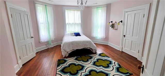 615 N Jefferson St, Carrollton, MO 64633 - bedroom featuring dark wood finished floors and a chandelier