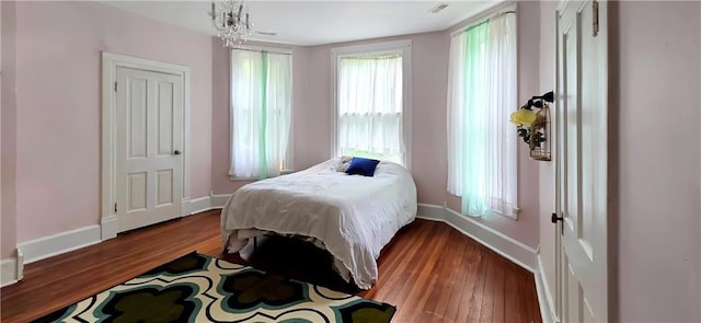 615 N Jefferson St, Carrollton, MO 64633 - bedroom featuring wood finished floors and a chandelier