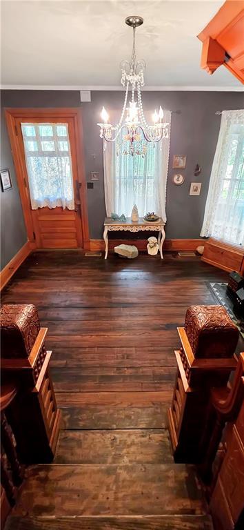 615 N Jefferson St, Carrollton, MO 64633 - dining area with dark wood-type flooring, a chandelier, and crown molding