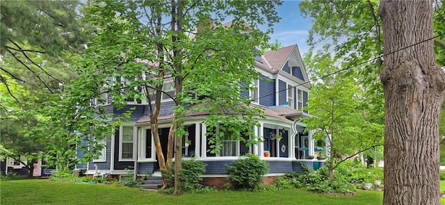 615 N Jefferson St, Carrollton, MO 64633 - rear view of house with a lawn and a sunroom