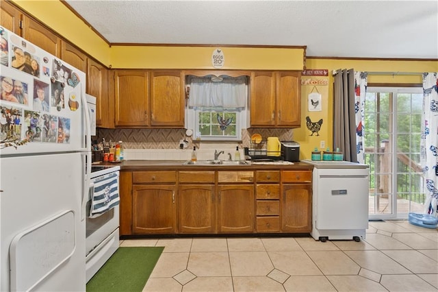 117 Ellison Way, Independence, MO 64050 - kitchen featuring white appliances, brown cabinetry, tasteful backsplash, a textured ceiling, and ornamental molding