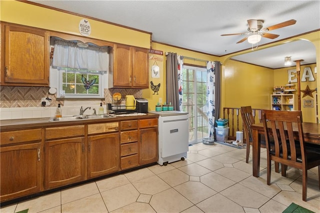 117 Ellison Way, Independence, MO 64050 - kitchen with brown cabinetry, decorative backsplash, a ceiling fan, ornamental molding, and a textured ceiling