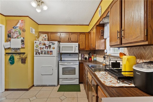 117 Ellison Way, Independence, MO 64050 - kitchen with white appliances, brown cabinets, a textured ceiling, dark countertops, and light tile patterned floors