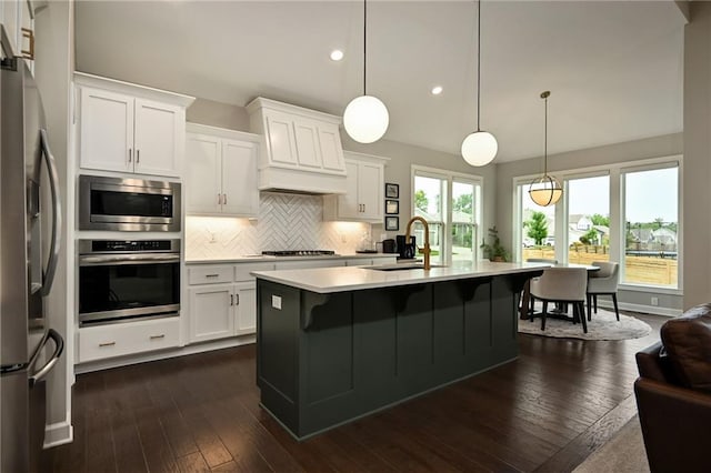 144 SE Riley St, Blue Springs, MO 64064 - kitchen with appliances with stainless steel finishes, tasteful backsplash, light countertops, recessed lighting, and premium range hood