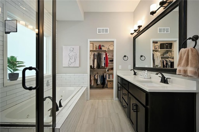144 SE Riley St, Blue Springs, MO 64064 - full bathroom featuring a jetted tub, double vanity, and a walk in closet
