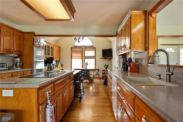 23800 Lucille Ln, Peculiar, MO 64078 - kitchen featuring black electric cooktop, brown cabinetry, built in microwave, and oven
