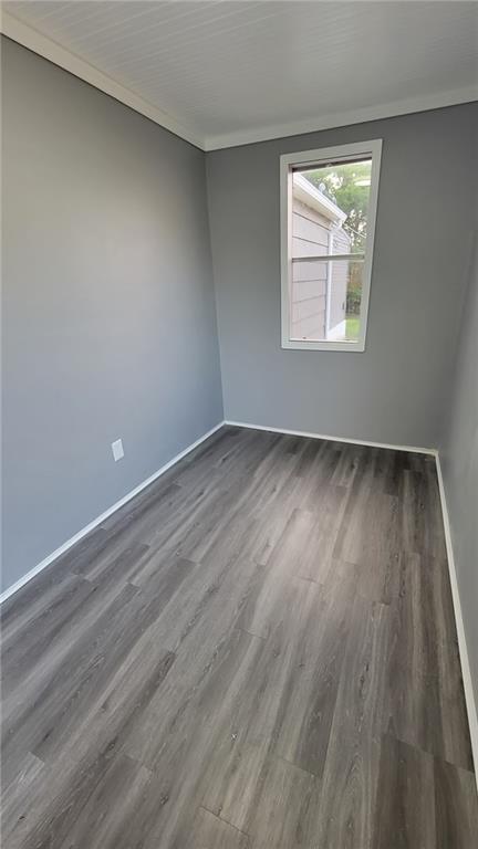 4216 E 67th Ter, Kansas City, MO 64132 - spare room featuring dark wood-type flooring and baseboards