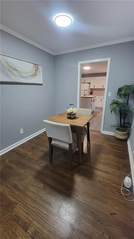 4216 E 67th Ter, Kansas City, MO 64132 - dining room with crown molding and dark wood-type flooring
