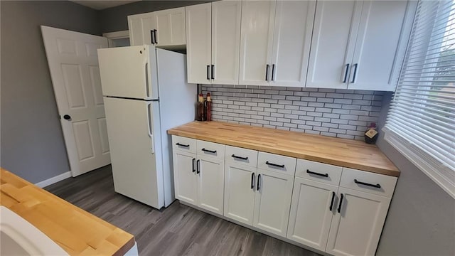 4216 E 67th Ter, Kansas City, MO 64132 - kitchen with wooden counters, freestanding refrigerator, dark wood-style flooring, and decorative backsplash