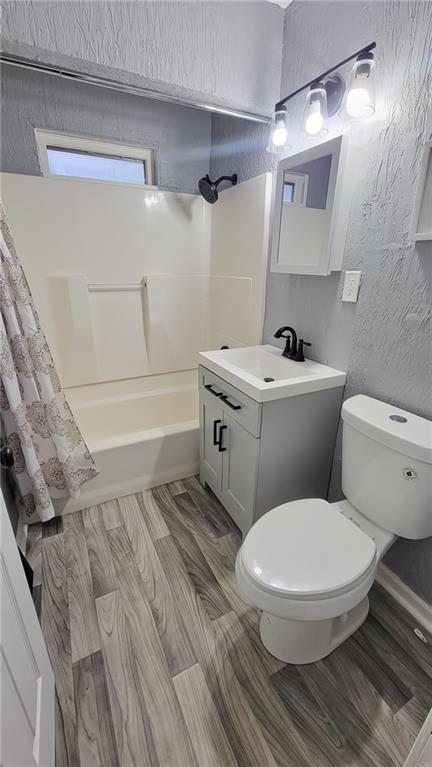 4216 E 67th Ter, Kansas City, MO 64132 - full bath with vanity, shower / bathtub combination with curtain, and a textured wall