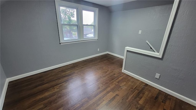 4216 E 67th Ter, Kansas City, MO 64132 - spare room featuring baseboards and dark wood-style flooring