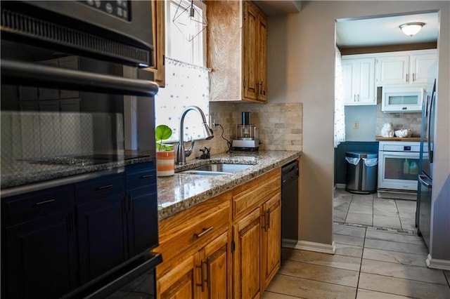 1902 Snowdrop Cir, Liberty, MO 64068 - kitchen featuring black appliances, backsplash, light stone countertops, brown cabinetry, and light tile patterned floors