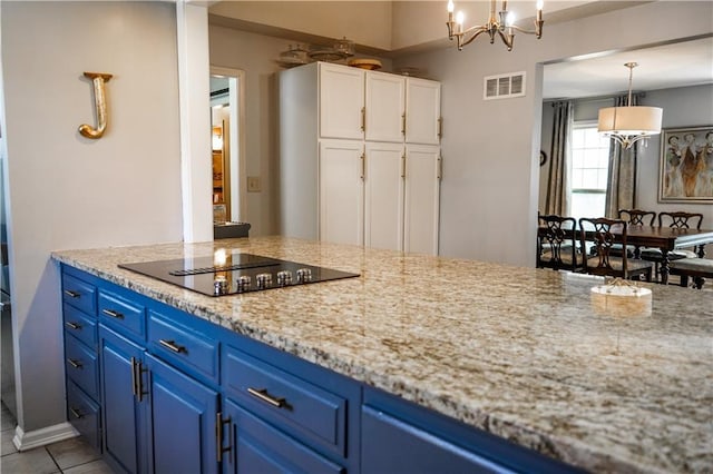 1902 Snowdrop Cir, Liberty, MO 64068 - kitchen with black electric stovetop, blue cabinetry, white cabinetry, and a chandelier
