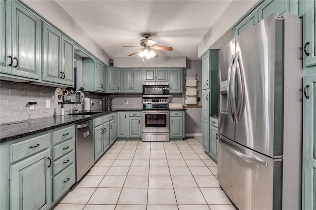 34065 W 135th St, Olathe, KS 66061 - kitchen with appliances with stainless steel finishes, ceiling fan, decorative backsplash, light tile patterned flooring, and dark stone countertops