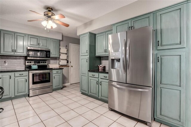 34065 W 135th St, Olathe, KS 66061 - kitchen featuring stainless steel appliances, backsplash, a ceiling fan, green cabinets, and a textured ceiling