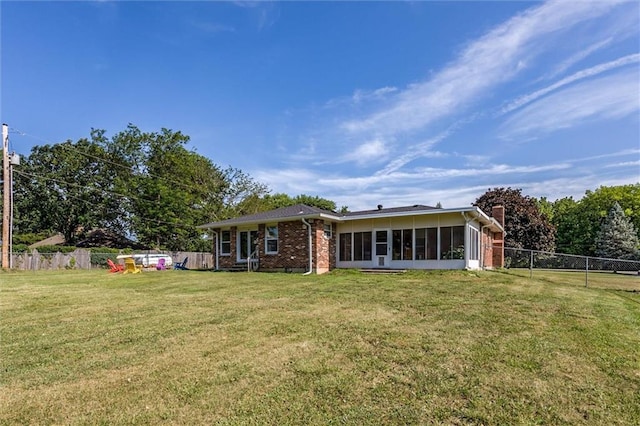 34065 W 135th St, Olathe, KS 66061 - rear view of house with brick siding, a fenced backyard, and a sunroom